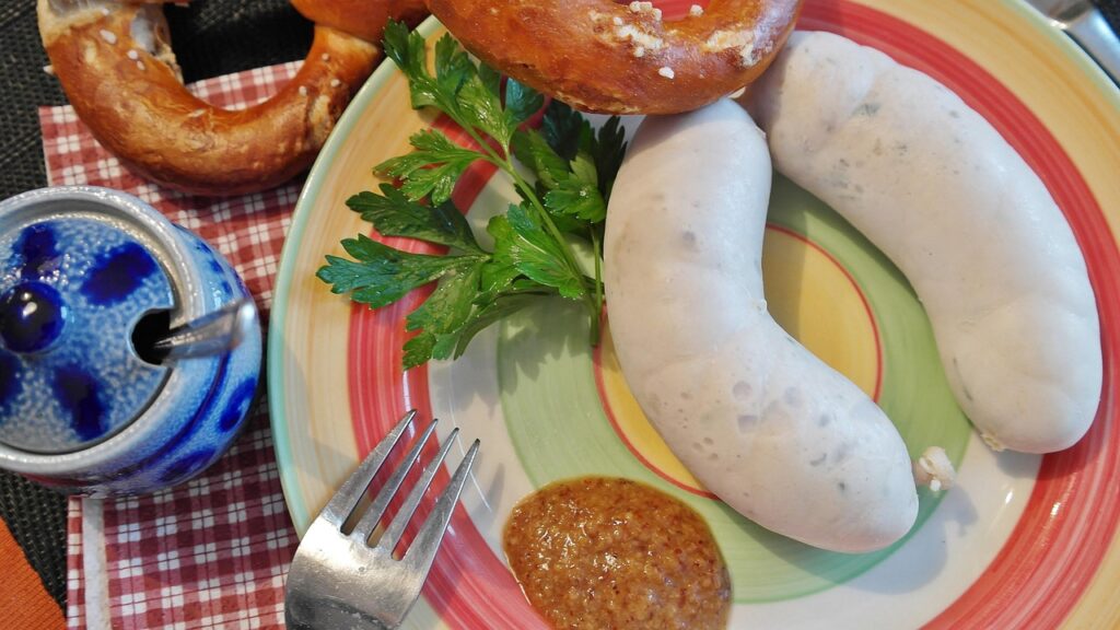 Weißwurst with a pretzel and a jar of sweet mustard