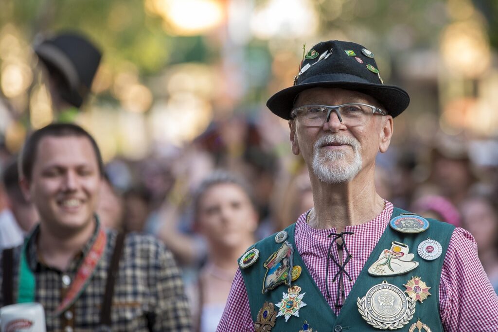 A man in Lederhosen, a Trachten shirt and a hat with a Gamsbart at the Oktoberfest