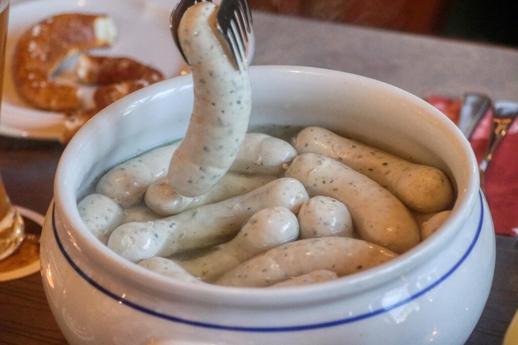 Bavarian Weißwurst in a bowl with a pretzel and sweet mustard