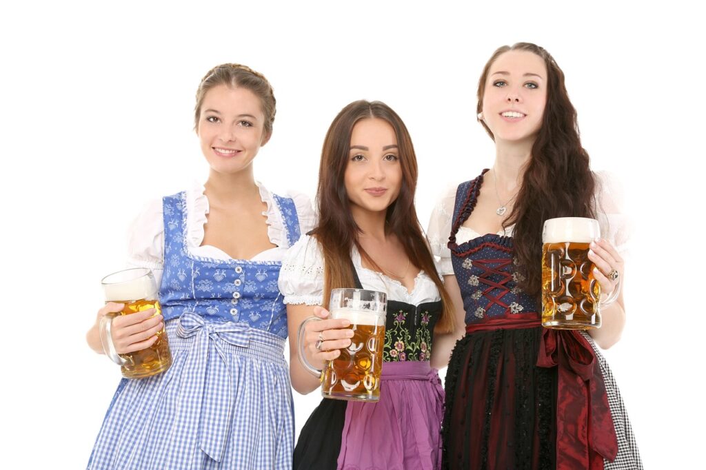 Two women in Dirndls holding beer mugs